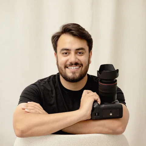Chand Anand smiling beside a professional camera